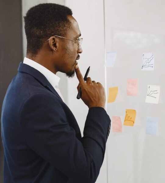 African man in a black suit. Man writing on the glass.